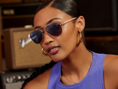 Tortoiseshell, and Black Aviator eyeglasses displayed on a red table.